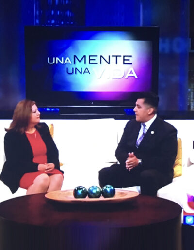 Dr. Ximenez talking to a TV host on a couch.
